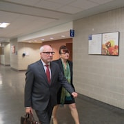 Une femme et un homme se déplacent dans le couloir d'un palais de justice.